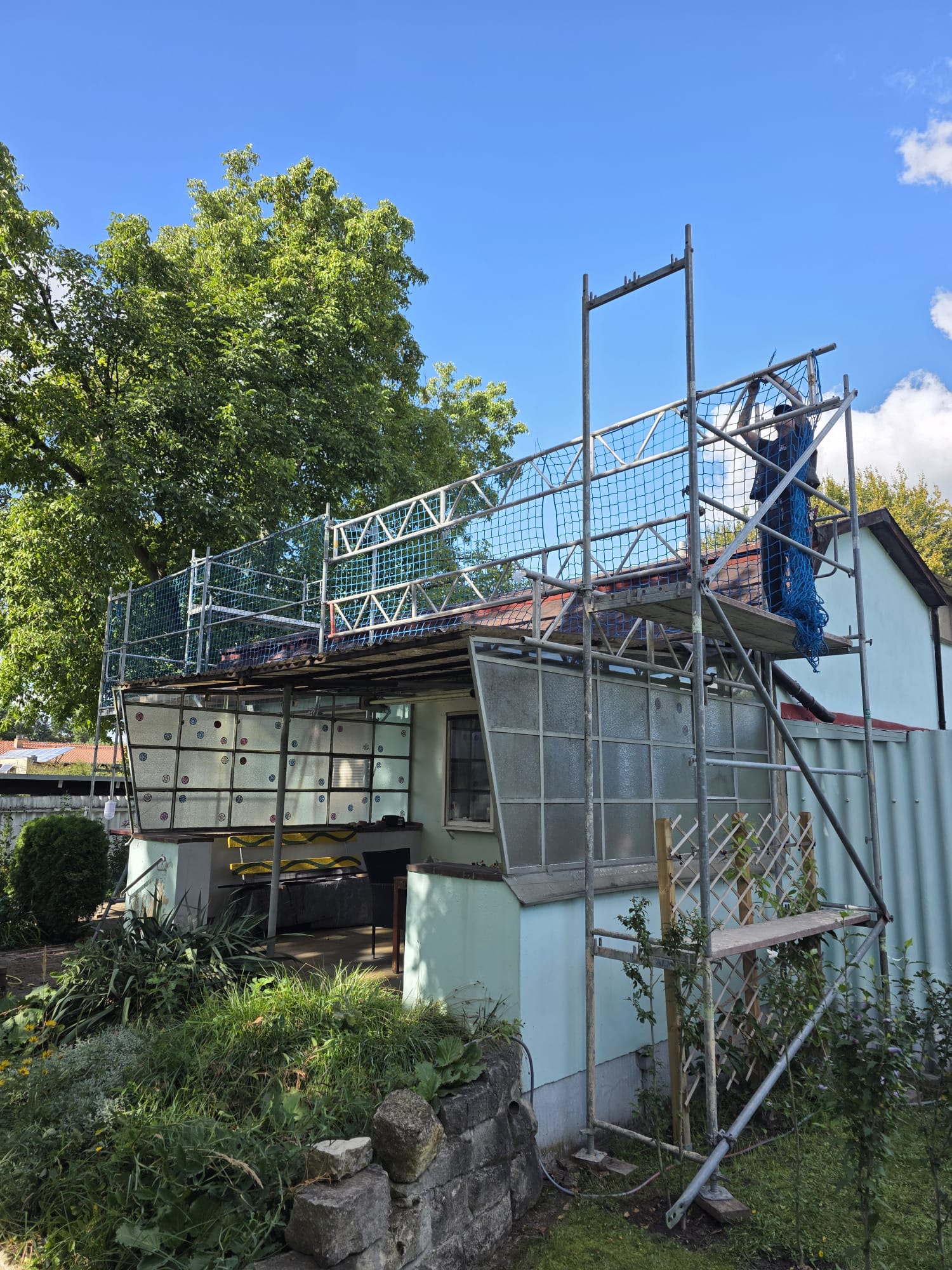 Sicherungsnetze am Gerüst auf Gartenhaus