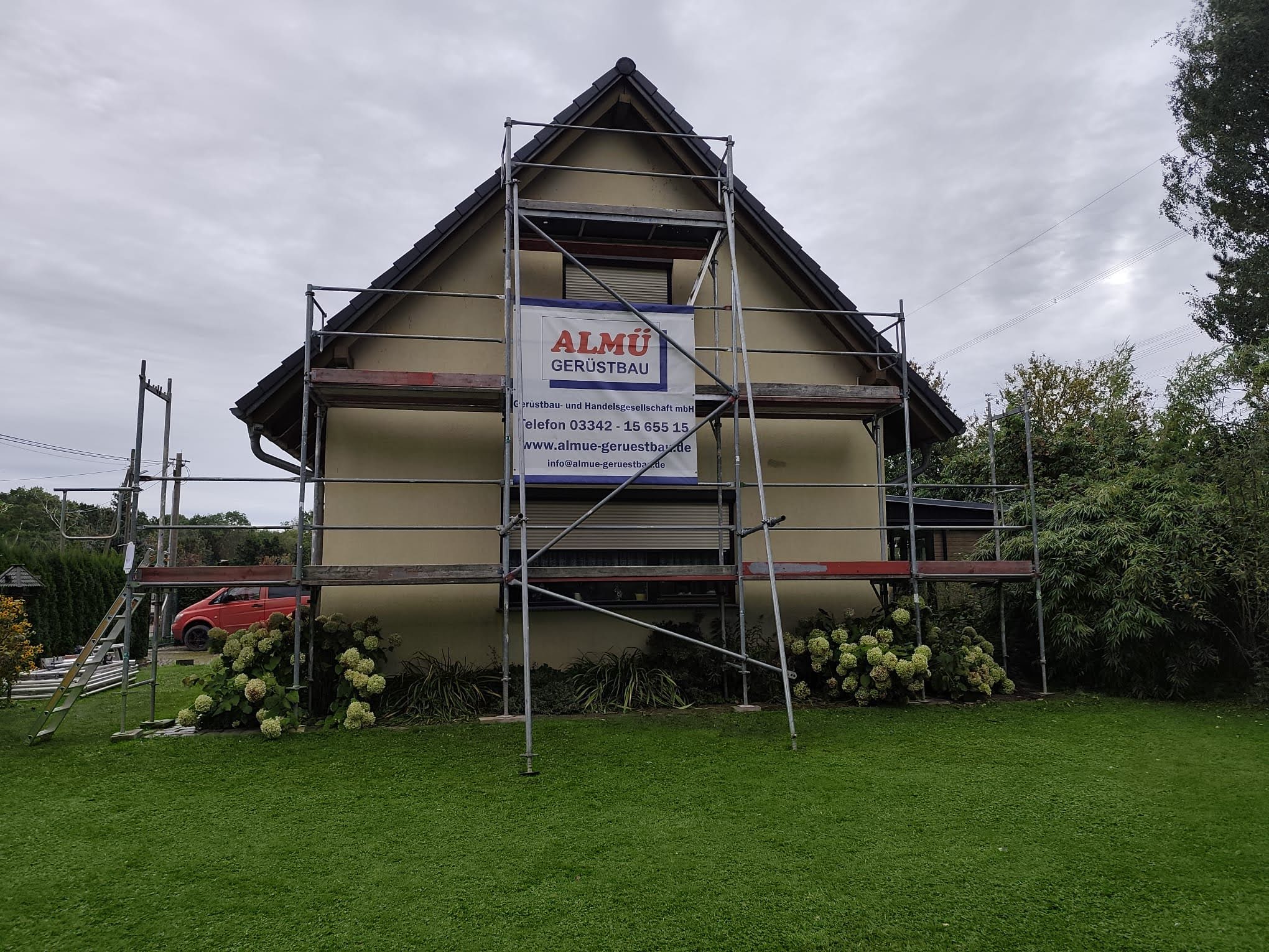 Einfamilienhaus mit ALMÜ Werbeplane am Gerüst